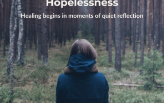 Person standing quietly in a forest, symbolizing reflection, healing, and hope in overcoming isolation and hopelessness.
